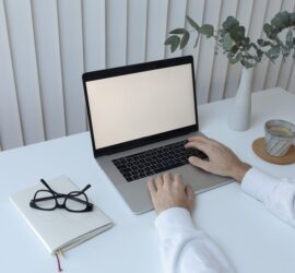 crop person typing on laptop in office